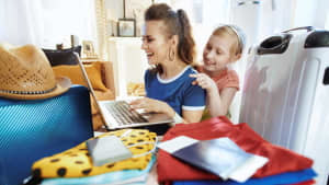 Eine Mutter bucht am Laptop eine Reise mit ihrer Tochter