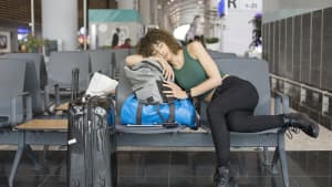 Junge Frau schläft am Flughafen