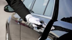 die Tür eines Autos wird vom Chauffeur oder Hotelngestellten geöffnet