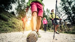 Nahaufnahme von einem Mann mit Nordic Walking Stöcken, der  mich zuläuft