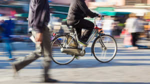 Ein Fußgänger und ein Fahrradfahrer auf der Strasse