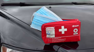 Ein kleines Auto-Verbands-Set mit Corona-Masken für die Erste-Hilfe Versorgung