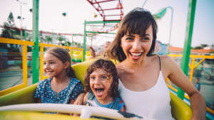 Frau fährt mit Kindern in der Achterbahn