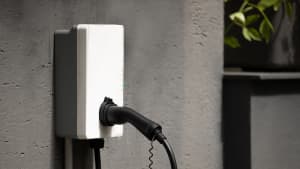 Steckerhalter für Wandladestation mit Kabel an der Wandbox, montiert an der Hauswand aus Beton