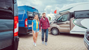 Junges Paar sieht sich Wohnmobile an, die zum Verkauf stehen