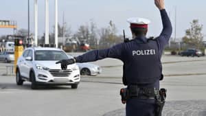Ein österreichischer Polizist winkt einen PKW aus dem Verkehr