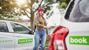 Eine Frau öffnet ein Car sharing Auto