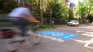 Mann fährt mit seinem Fahrrad auf einer Fahrradstraße