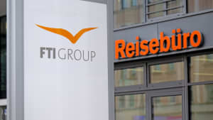 Das Firmenloge oder FTI Group vor einem Reisebüro