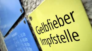 gelbes Schild an einer Mauer Gelbfieber Impfstelle