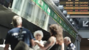 Menschen vor Anzeigetafeln am Flughafen