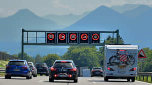 Autos fahren auf einer Autobahn unter einem Geschwindigkeits-Begrenzungsschild