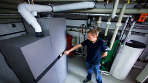 Ein Techniker steht vor einer Brennstoffzellen-Heizungsanlage