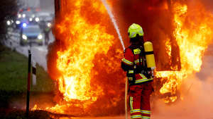 Eine Feuerwehrmann löscht auf der Autobahn das Feuer eines explodierten Lasters