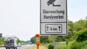 Ein Schild an der Autobahn A60 weist auf den Einsatz eines neuartigen Systems zur Feststellung von Handyverstößen am Steuer hin .