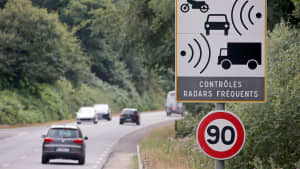 Ein Schild mit dem Hinweis zur automatischen Blitzkontrolle steht an einer Straße in Frankreich