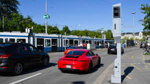 Roter Porsche fährt an einem Blitzer in der Innenstadt von Zürich vorbei