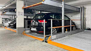 PKWÕs stehen in einer Tiefgarage auf Doppelparkern. *** Cars are parked in an underground garage on double parking spaces