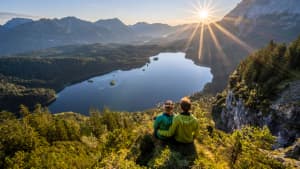Pärchen sitzt auf einem Felsvorsprung und blickt auf den Eibsee