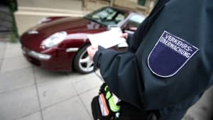Eine Politesse schreibt einen Strafzettel fürs Falsch parken