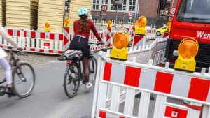 Radfahrerin fährt durch eine Baustelle