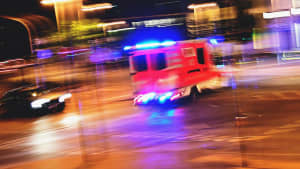 Ein Rettungswagen mit Blaulicht fährt über eine Kreuzung