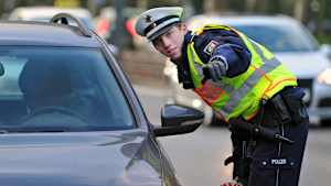 Ein Polizist hält  in Düsseldorf (Nordrhein-Westfalen) ein Fahrzeug aufgrund einer Geschwindigkeitsüberschreitung an.