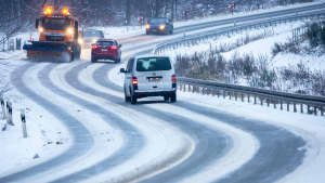 Ein Schneepflug räumt eine Bundesstraße von Schnee