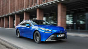 Ein blauer Toyota Mirai fährt auf einer Straße