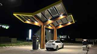 Ein Tesla Model Y an einer Ladestation bei Nacht