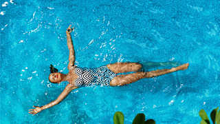Eine Frau erholt isch im Pool beim schwimmen