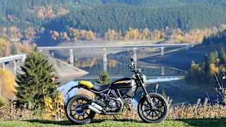 Ein Motorrad steht vor einem See bei Schulenberg im Harz