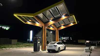 Ein Tesla Model Y an einer Ladestation bei Nacht