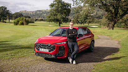 Aufnahme des stehenden Audi Q3 ADAC Redakteur Andreas Huber im Vordergrund