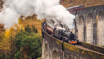 Ein Zug der West Highland Line fährt über das Glenfinnan Viadukt in Schottland