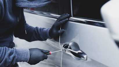 Nahaufnahme Autodieb Hand halten Schraubendreher Sabotage Ruck und Handschuh schwarz stehlen Auto versucht Türgriff zu sehen, ob Fahrzeug entriegelt ist und versucht, ins Innere einzudringen
