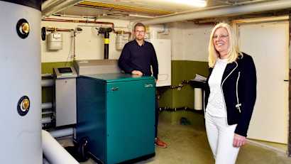 Ein Blockheizkrafterk im Keller eines Einfamilienhauses wessen Besitzer glücklich davor stehen