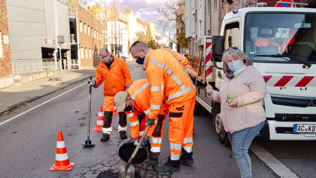 Straßenarbeiter verfüllen ein Schlagloch