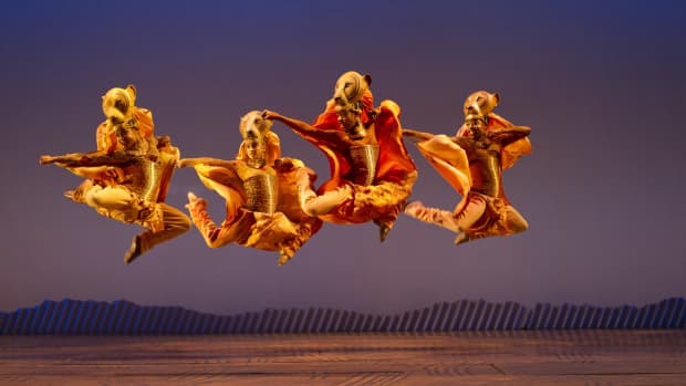 Szene im Musical König der Löwen, Darsteller springen gerade in die Luft