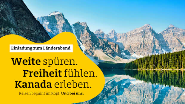 Ein blauer See, gesäumt von Wald, liegt vor schneebedeckten Bergen.