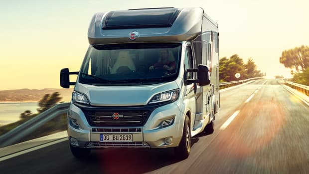 Ein modernes Bürstner Wohnmobil, das auf entlang einer malerischen Küstenlandschaft bei Sonnenuntergang fährt, und Wohnmobil mieten tipps aufzeigt.
