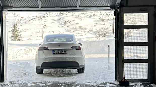 Tesla Model Y vor der am Tor der Hotelgarage in der Winterlandschaft von Obertauern  