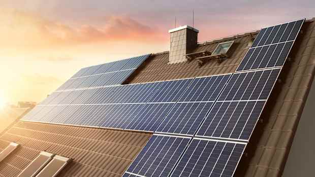 Solaranlage auf einem Hausdach bei Sonnenaufgang.