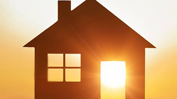 Silhouette eines Hauses, durch dessen offene Tür und Fenster die Sonne scheint, um zu zeigen, dass die Verbindung Photovoltaik E-Auto gut funktioniert.