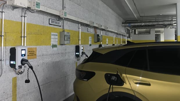 Ein goldenes Auto steht in einer Garage an einer Ladestation, denn ein E-Auto laden beim Arbeitgeber ist kein Problem.