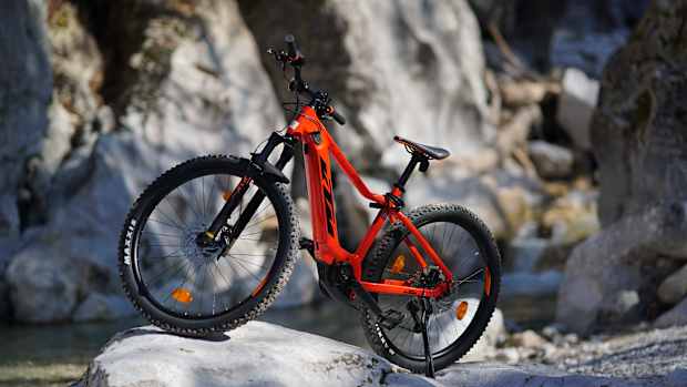 Ein rotes Fahrrad steht an einem Berg und zeigt auch beim ein e-bike gebraucht kaufen muss man keine Sorgen haben.