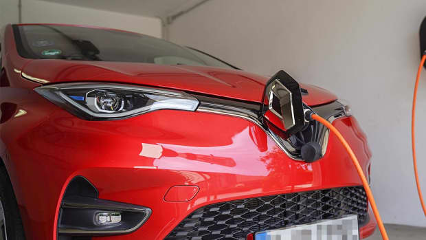 Ein rotes E-Auto wird an einer Wallbox in der Garage geladen, denn nun kann man Zuhause E-Autos laden