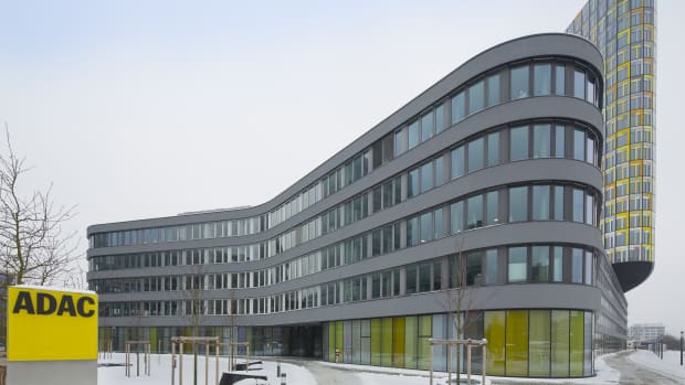 ADAC Zentrale von der Seite mit ADAC Logo im Vordergrund und verschneitem Gelände
