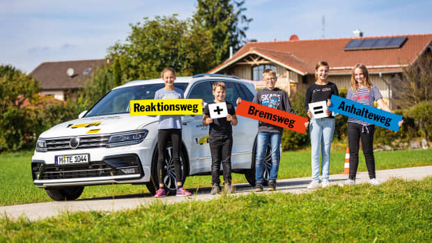 Kinder des Ehrenamts ADAC halten Verkehrserziehung Schilder hoch