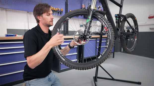 ADAC Mitarbeiter Matthias Zimmermann wechselt die Bremsbeläge am Fahrrad